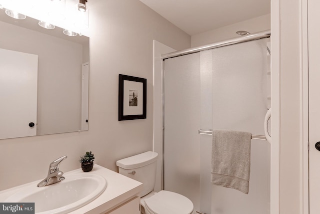 full bathroom with vanity, a shower stall, and toilet