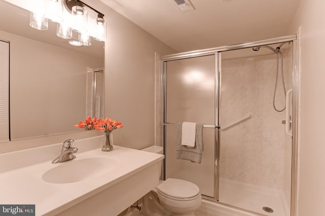 full bathroom featuring toilet, a stall shower, a sink, and visible vents