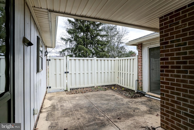 view of patio with fence and a gate