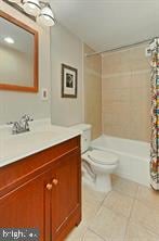 bathroom with tile patterned flooring, vanity, toilet, and shower / bath combo with shower curtain