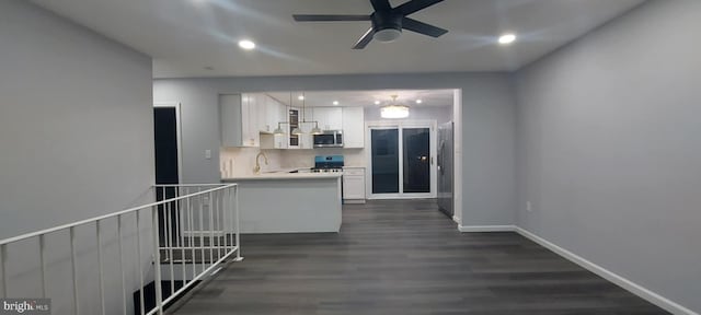 kitchen featuring a sink, dark wood-type flooring, light countertops, appliances with stainless steel finishes, and white cabinetry