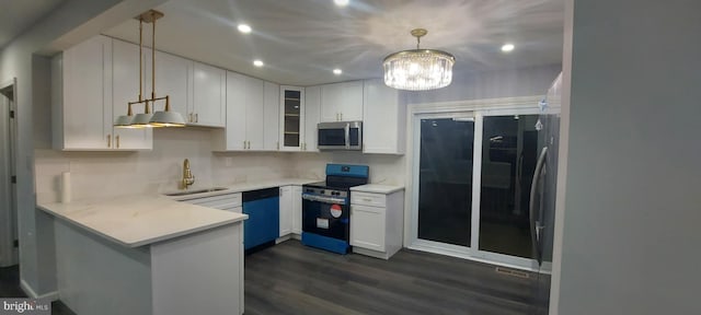 kitchen featuring a peninsula, a sink, white cabinets, glass insert cabinets, and appliances with stainless steel finishes