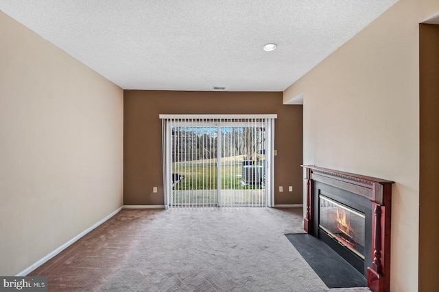 unfurnished living room with a fireplace with flush hearth, carpet flooring, a textured ceiling, and baseboards