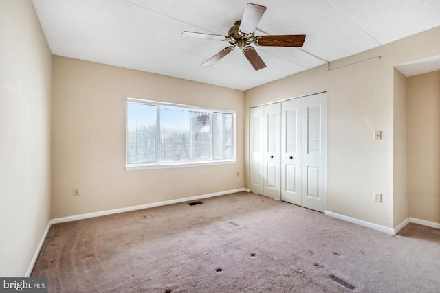 unfurnished bedroom with carpet floors, a closet, visible vents, and baseboards