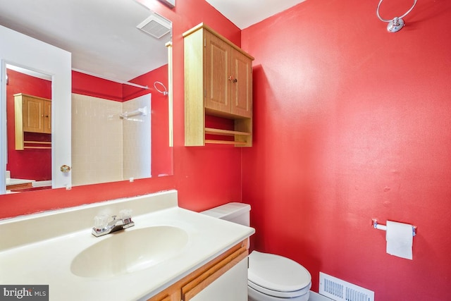 bathroom with toilet, walk in shower, vanity, and visible vents