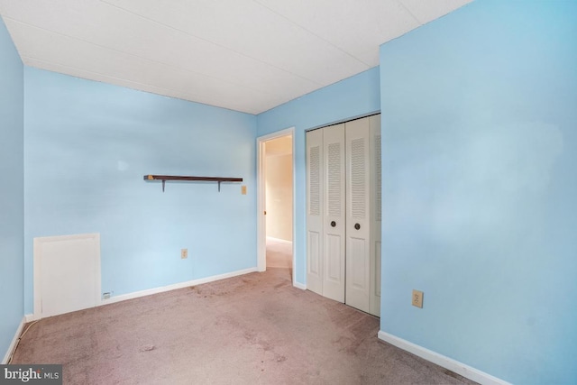 unfurnished bedroom featuring carpet floors, a closet, and baseboards