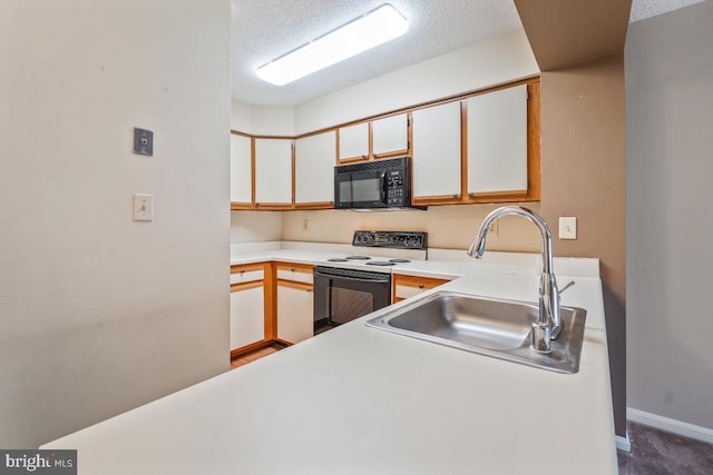 kitchen with black microwave, a textured ceiling, a sink, light countertops, and electric range oven