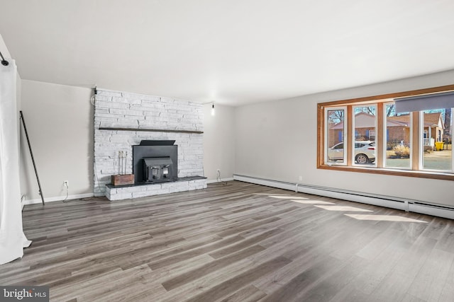 unfurnished living room with a baseboard radiator, wood finished floors, and baseboards