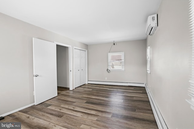 unfurnished bedroom featuring a wall unit AC, a baseboard radiator, a baseboard heating unit, wood finished floors, and baseboards