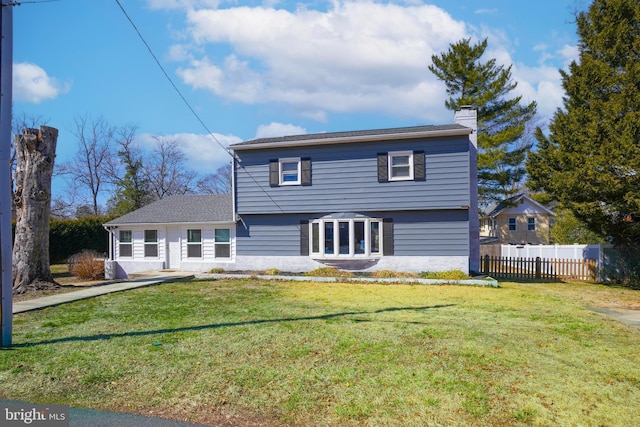 view of front of home with a chimney, fence, and a front lawn