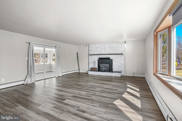 unfurnished living room with a baseboard radiator, a fireplace, baseboards, and wood finished floors