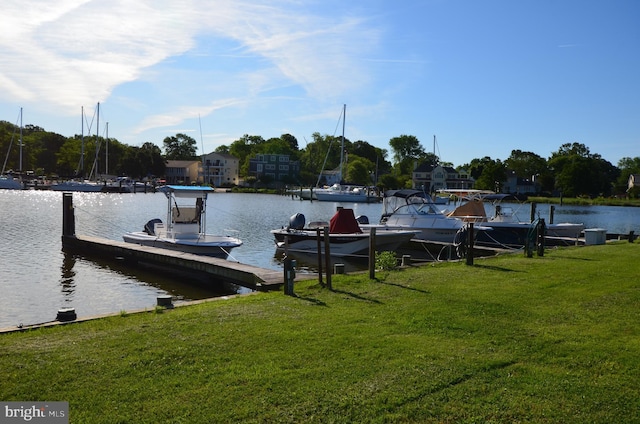 view of dock featuring a water view and a yard