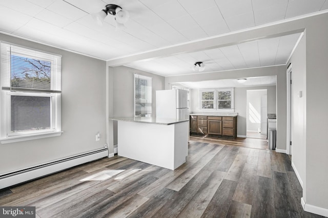 kitchen with dark wood-style floors, a baseboard radiator, freestanding refrigerator, a peninsula, and crown molding