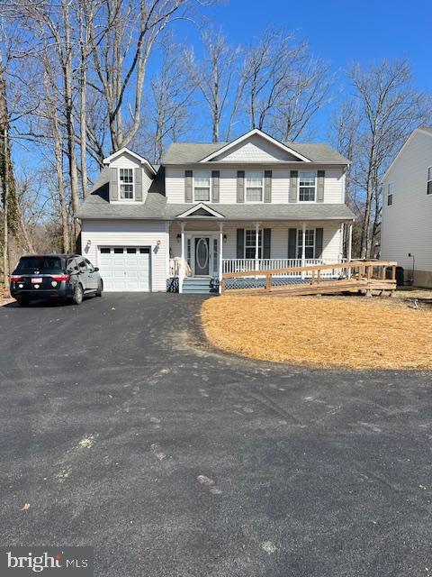 traditional-style home with driveway, a garage, and a porch