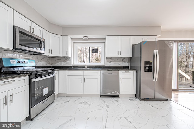 kitchen featuring marble finish floor, plenty of natural light, appliances with stainless steel finishes, and a sink