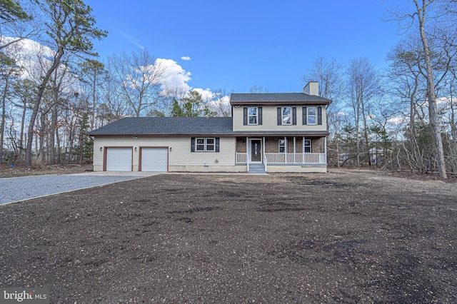 view of front of home featuring driveway, a chimney, an attached garage, covered porch, and brick siding