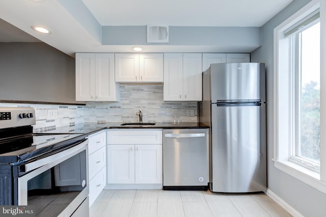 kitchen featuring appliances with stainless steel finishes, a healthy amount of sunlight, visible vents, and a sink