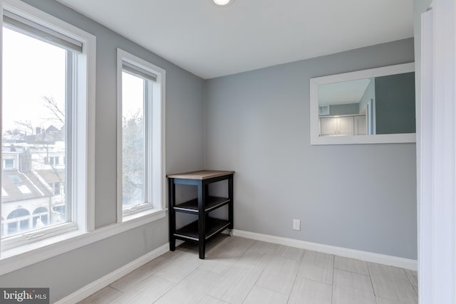 unfurnished room with baseboards and a healthy amount of sunlight