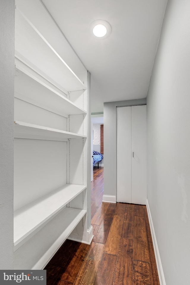 interior space with wood-type flooring and baseboards