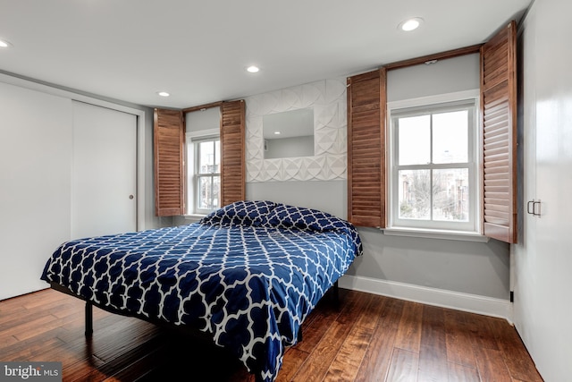 bedroom featuring hardwood / wood-style floors, a closet, recessed lighting, and baseboards