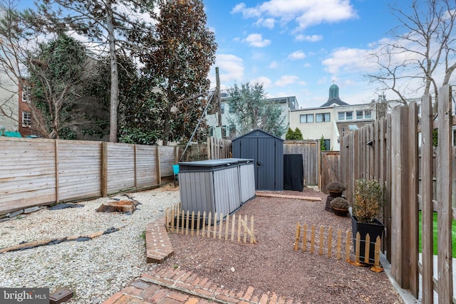 view of yard with a storage unit, an outdoor structure, and a fenced backyard