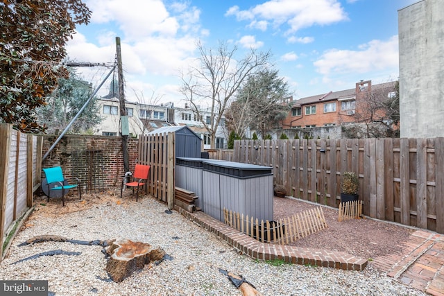 exterior space featuring an outbuilding, a storage unit, a fenced backyard, and a residential view