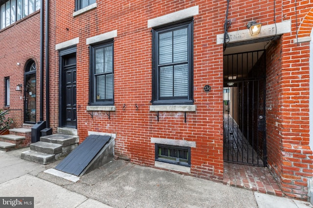 doorway to property featuring brick siding