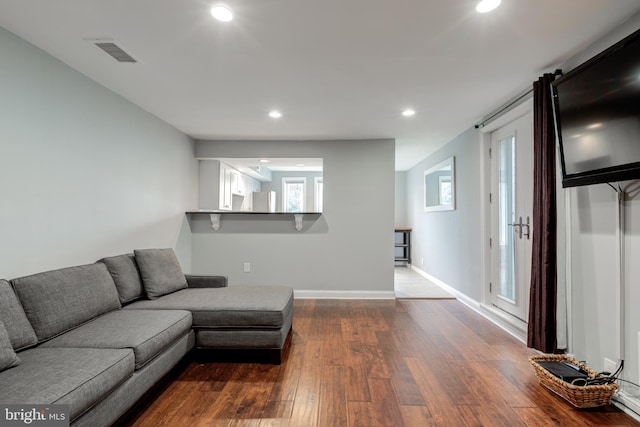 living room featuring baseboards, visible vents, dark wood-type flooring, and recessed lighting