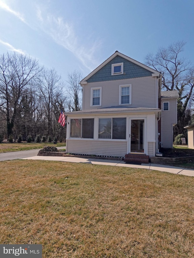 view of front of home with entry steps and a front lawn