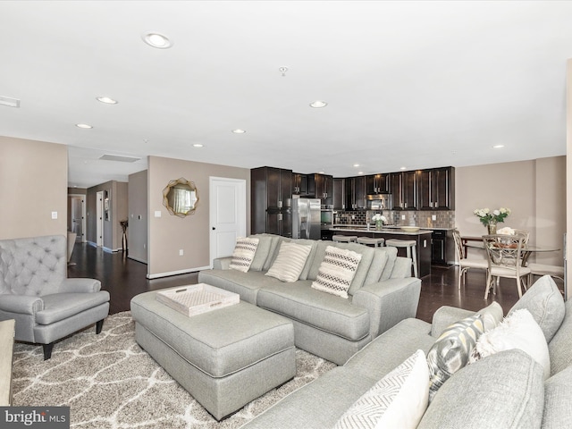 living room featuring recessed lighting and dark wood finished floors