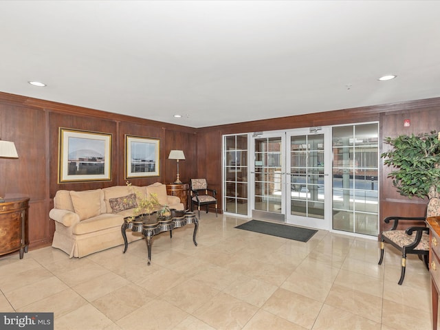 living room featuring wooden walls, recessed lighting, french doors, and ornamental molding