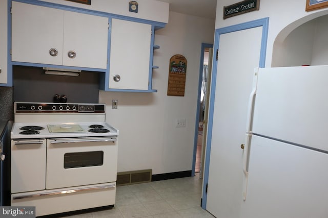 kitchen featuring white appliances, light tile patterned floors, baseboards, visible vents, and white cabinets