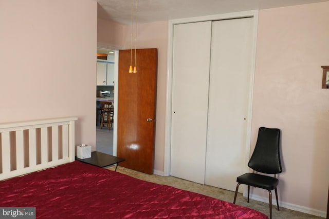 bedroom with a closet, baseboards, and carpet