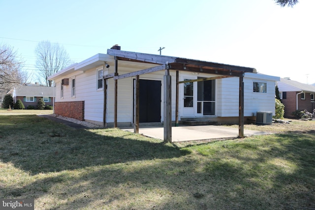 rear view of house with a patio area, a lawn, and central AC