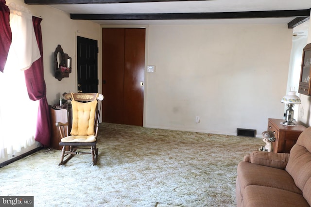 living area featuring beam ceiling, carpet flooring, and visible vents