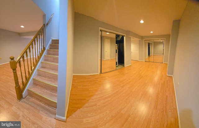 corridor featuring recessed lighting, wood finished floors, and baseboards