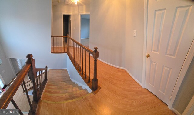 stairway featuring wood finished floors and baseboards