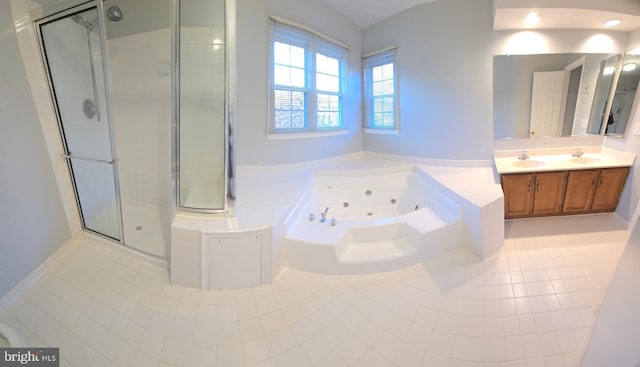 full bath with a sink, a shower stall, a tub with jets, and double vanity