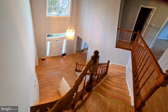 entrance foyer featuring visible vents, stairway, and wood finished floors