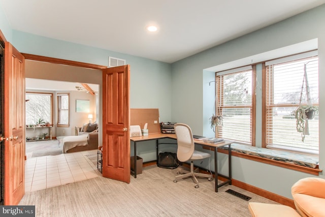 office area with visible vents, light carpet, and baseboards