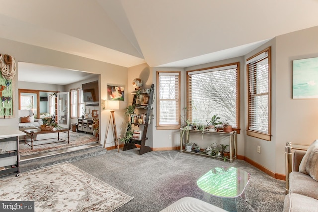 carpeted living area featuring lofted ceiling and baseboards