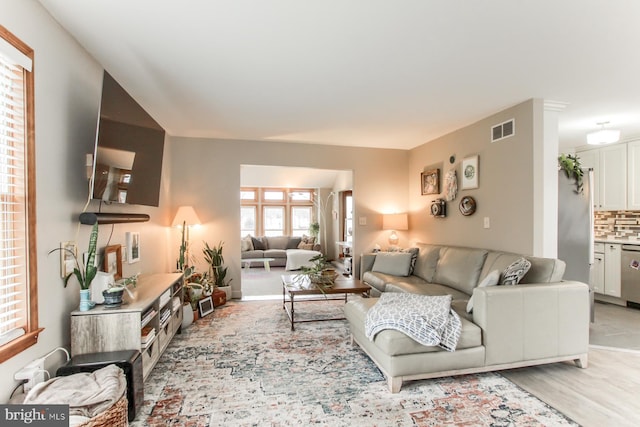 living area featuring light wood finished floors and visible vents