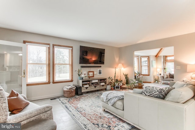 living area featuring baseboards, plenty of natural light, and visible vents