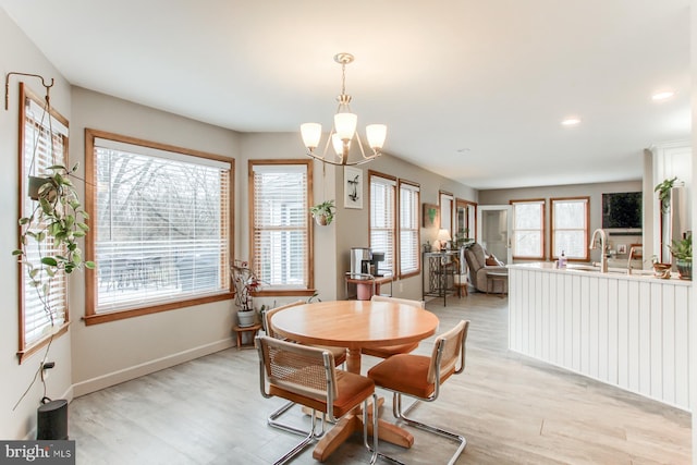 dining space featuring a chandelier, plenty of natural light, light wood-type flooring, and baseboards