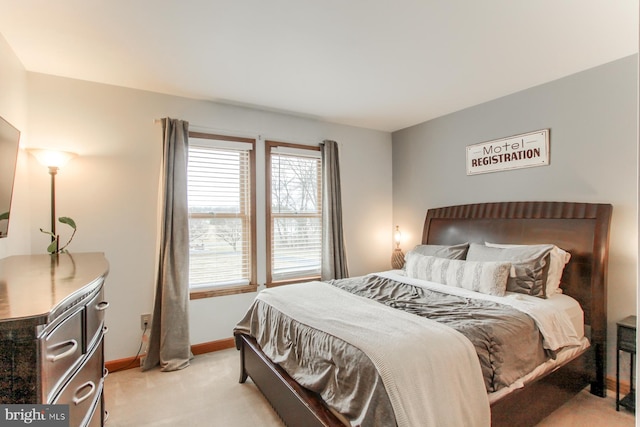 bedroom featuring light carpet and baseboards