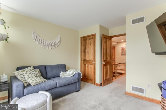 living area featuring baseboards, visible vents, and carpet floors