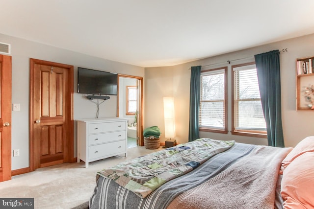 bedroom featuring visible vents, light colored carpet, and baseboards