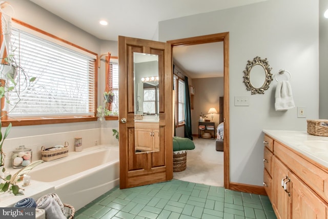 ensuite bathroom featuring vanity, a garden tub, and connected bathroom