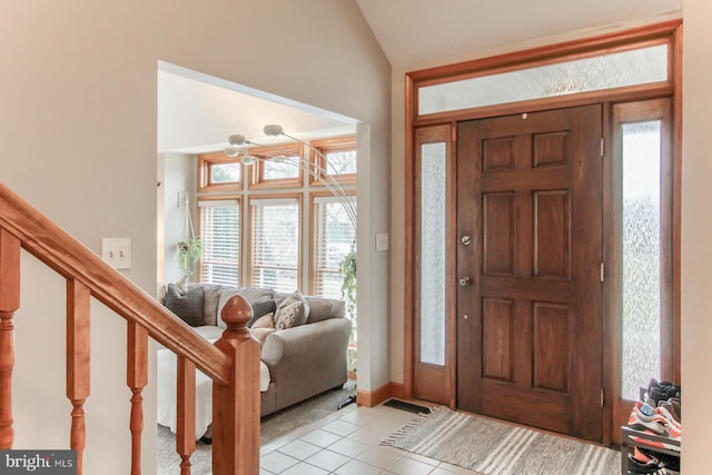 foyer entrance featuring lofted ceiling, stairway, light tile patterned floors, and visible vents