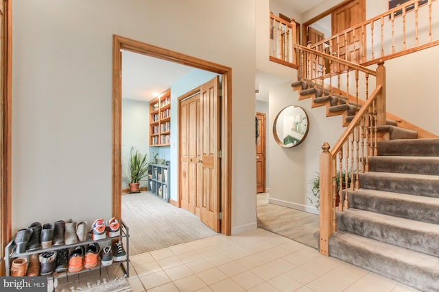 interior space with tile patterned floors, baseboards, and a high ceiling